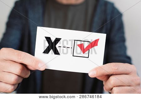 closeup of a young caucasian person holding a piece of paper with a X written in it, for the third gender category