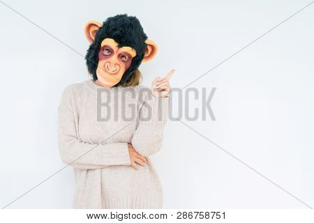 Middle age woman wearing funny and crazy money mask over isolated background very happy pointing with hand and finger to the side
