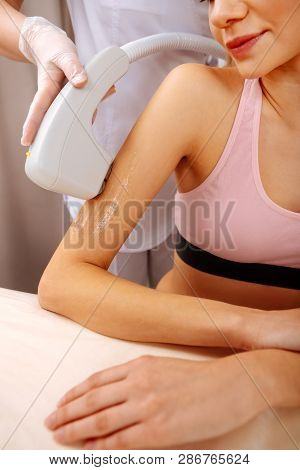 Woman Wearing Pink Top Having Painless Photo Depilation Of Arm