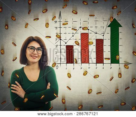 Casual Young Woman Wearing Glasses, Arms Crossed, Smiling Broadly As Finanicial Graph Raise And Gold