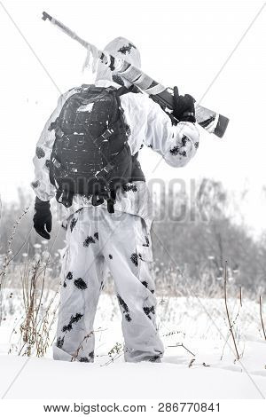 Man Soldier In The Winter On A Hunt With A Sniper Rifle In White Winter Camouflage Stay In The Snow