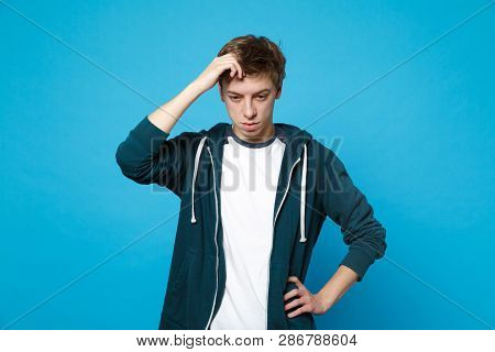 Portrait Of Preoccupied Young Man In Casual Clothes Looking Down And Putting Hand On Head Isolated O