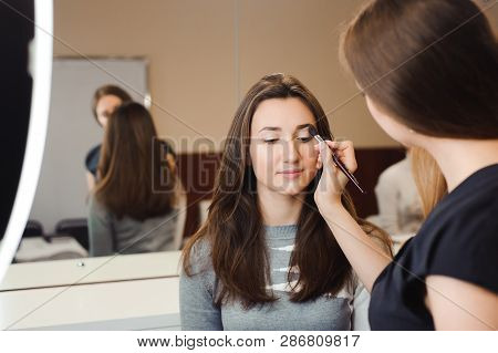 Make Up Artist Doing Professional Make Up Of Young Woman. Beauty Shcool