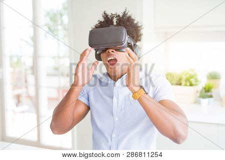 African amaerican man having fun playing with virtual reality glasses