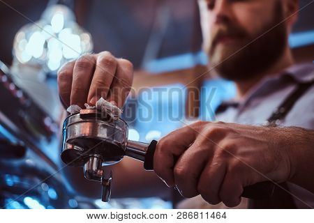 Low Angle Photo Of A Barista Cleans The Portafilter Before Preparing The Cappuccino In A Coffee Shop