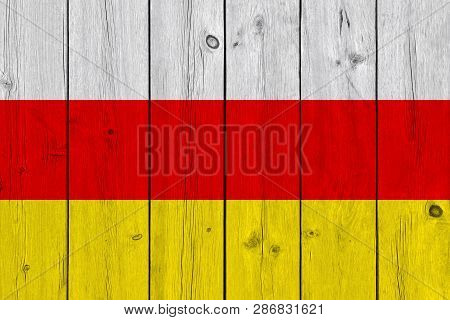 South Ossetia Flag Painted On Old Wood Plank. Patriotic Background. National Flag Of South Ossetia