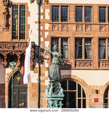 Lady Justice Standing At The Fountain Under Blue Sky In Frankfurt As A Symbol Of Justice
