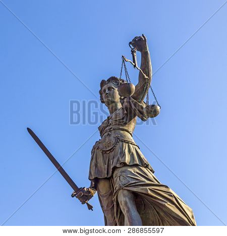 Lady Justice Standing At The Fountain Under Blue Sky In Frankfurt As A Symbol Of Justice