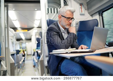 Businessman working on laptop in train