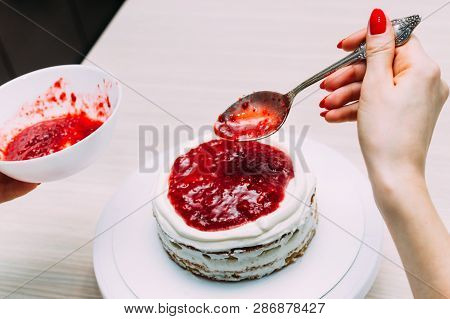 Housewife Puts Jam In The Process Of Making Sponge Cake. Woman Hands