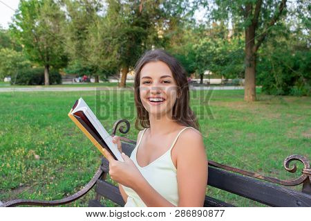Beautiful Young Brownhair Girl Is Reading The Book And Enjoys The Smell Of A Fresh Printed Book Sitt