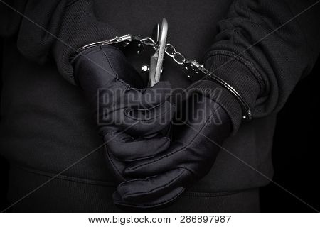 Arrested Man Trying To Cut The Handcuffs With A Cutter On His Back