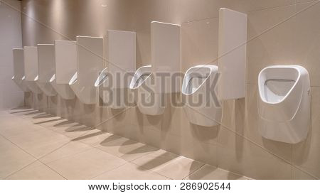 Row Of Modern Urinals In New Bathroom Of Theater