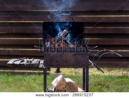 Burning Firewood And Preparing For Barbecue Outside In The Harden. Concept Of Summer Grilling, Barbe