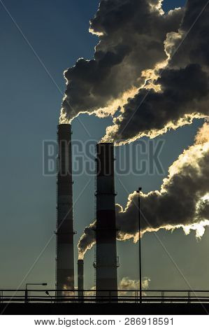 Dark Smoke From Two Industrial Chimneys Pipes On Blue Sky. Global Warming. Air Pollution.