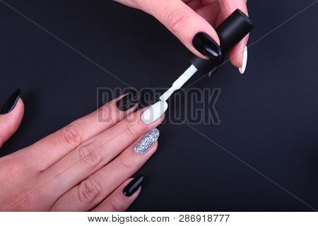 Black, White Nail Art Manicure. Holiday Style Bright Manicure With Sparkles. Bottle Of Nail Polish. 