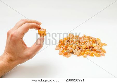 Man Holding Amber Stones In Hands From Baltic Sea. Multicoloured Background For Advertising And Bann