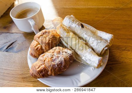 A White Plate With Food And A A White Cup Are On The Wooden Table. Ready To Eat Concept. Tasty Food 