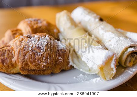 A White Plate With Food And A A White Cup Are On The Wooden Table. Ready To Eat Concept. Tasty Food 