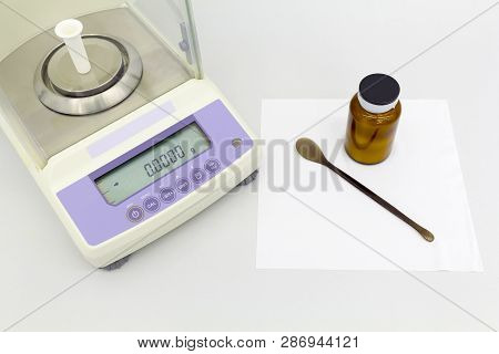 Laboratory Scale On Table With Materials In Bottles.