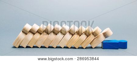 Wooden figures of people. Domino business concept. The leader does not stop the fall of employees. Weak link. Unreliable boss. Collapse and the crisis in the corporation. The fall of the company