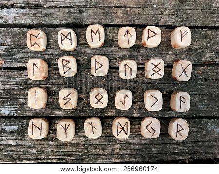 A Stack Of Wooden Runes At Forest. Wooden Runes Lie On A Old Wood Background. Runes Are Cut From Woo