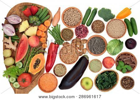 Alkaline health food for ph balance with vegetables, fruit, nuts, seeds, herbs, whole wheat pasta & grains. High in omega 3, antioxidants, anthocyanins, fibre, minerals & vitamins. Top view on white.