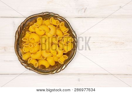 Lot Of Whole Raw Pasta Pipe Rigate Variety In Old Iron Bowl Flatlay On White Wood