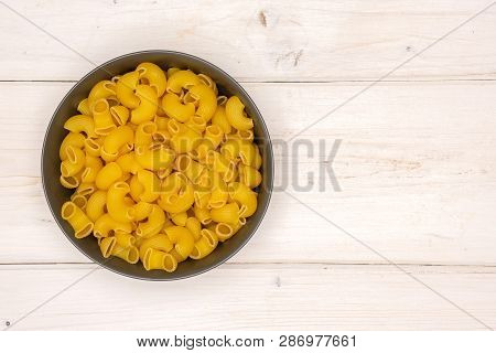 Lot Of Whole Raw Pasta Pipe Rigate Variety In A Grey Ceramic Bowl Flatlay On White Wood