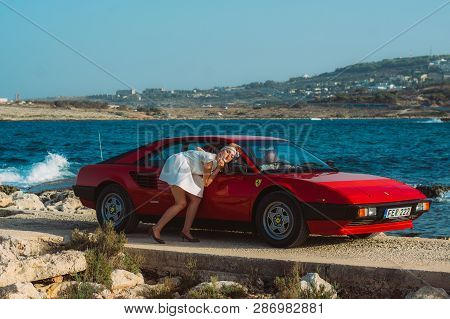 Young Girl Do Makeup In The Rear View Mirror Of Ferrari