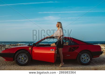 Young Beautiful Girl Posing Near The Red Ferrari