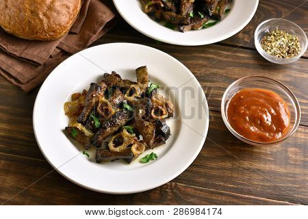 Roasted Beef Liver With Onion On Plate Over Wooden Table. Pieces Cooked Liver (offal) From Beef.