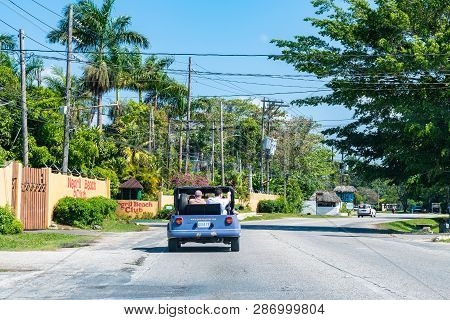 Negril, Jamaica - February 16 2019: Male Caucasian Tourists Driving In Topless Vehicle Near Negril B