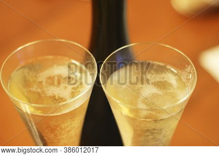 Bottle Of Shampagne And A Two Full Glasses Of Cold Shampagne Before Drinking On The Wooden Backgroun
