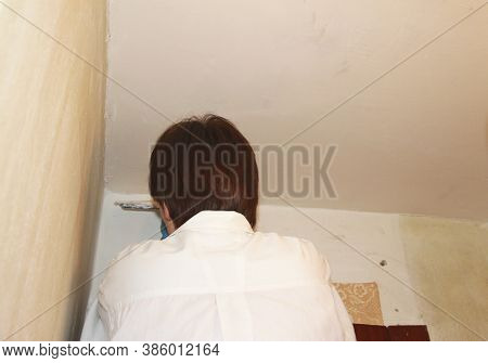 A Female Plasterer Painter Repairing A Ceiling Indoor