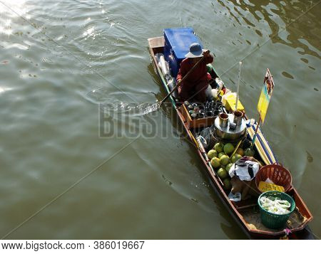 Amphawa, Thailand, January 23, 2016: A Man Paddles A Boat With Food On The Canal Of The Amphawa Floa