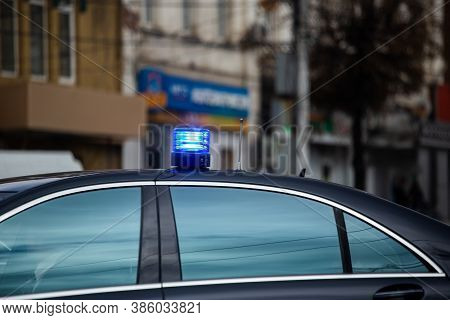 Blue Flashing Light On Top Of Black Government Car On Daytime City Street