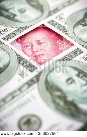 Yuan Banknote, Surrounded By 100 Dollar Bills. American Market Protectionism Concept