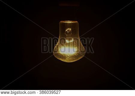 Old  Electric Light Bulb In A Dark Or Black Background