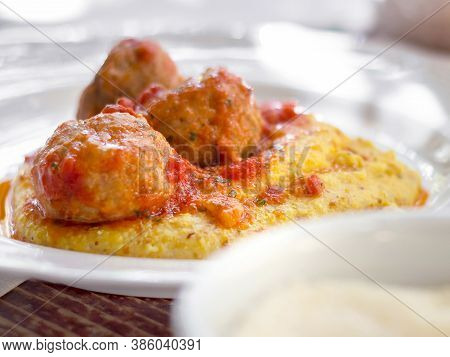 Polenta With Meatballs In Tomato Sauce. Traditional Italian Pork And Beef Meatballs Served On Polent