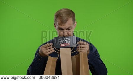 Surprised Man Showing Shopping Bags And Black Friday Deals Inscription In His Mouth. Good Holiday Sa