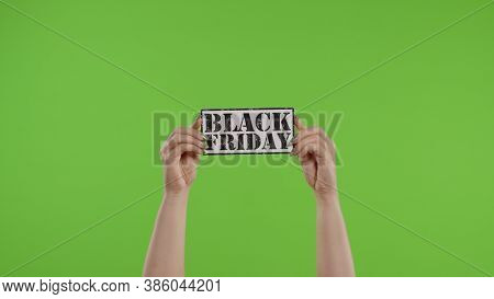 Black Friday Advertisement Inscription On Paper Sheet In Womans Hands On Green Screen. Holiday Disco