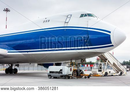 The Front Of Widebody Cargo Airplane With Towbar And Passenger Step Near