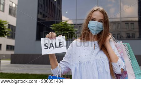 Young Stylish Model Girl In Protective Mask With Shopping Bags Showing Sale Word Inscription Text, L