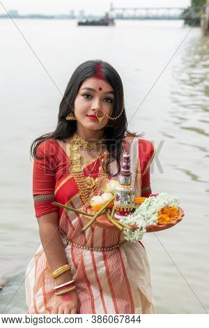 Portrait Of Beautiful Indian Girl Wearing Traditional Indian Saree, Gold Jewellery And Bangles Holdi