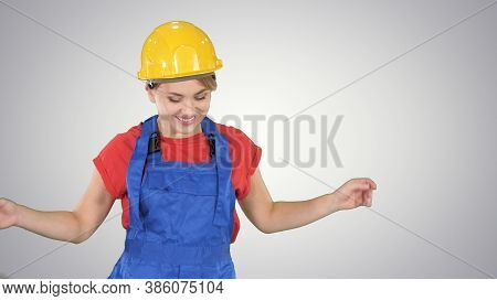 Woman In Construction Helmet Dancing On Gradient Background.