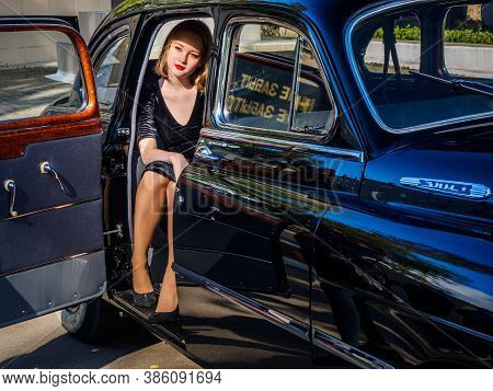 New Torial, Russia - September 12, 2020: Black Gaz 12 Zim At The Retro Car Show. Young Woman Posing 
