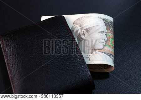 Seventy Five Of Banknote Currency Myanmar Kyats With Black Wallet On The Black Floor. It Is The Retr
