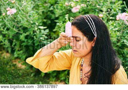 Woman Healer Holding Natural Mineral Kunzite Next To Head