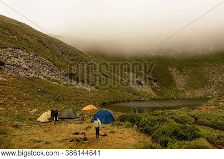 Morning Rain And Fog Near A Mountain Lake, Carpathian Lake Brebeneskul, A Tent Camp In The Fog.